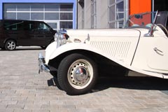 Oldtimer MG TD vor der Werkstatt, im Hintergrund VW Bus T5 Multivan